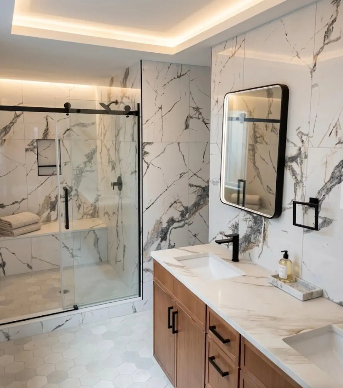 Bathroom with large-format marble-look wall tile, a glass shower with a recessed niche and hexagon floor tile