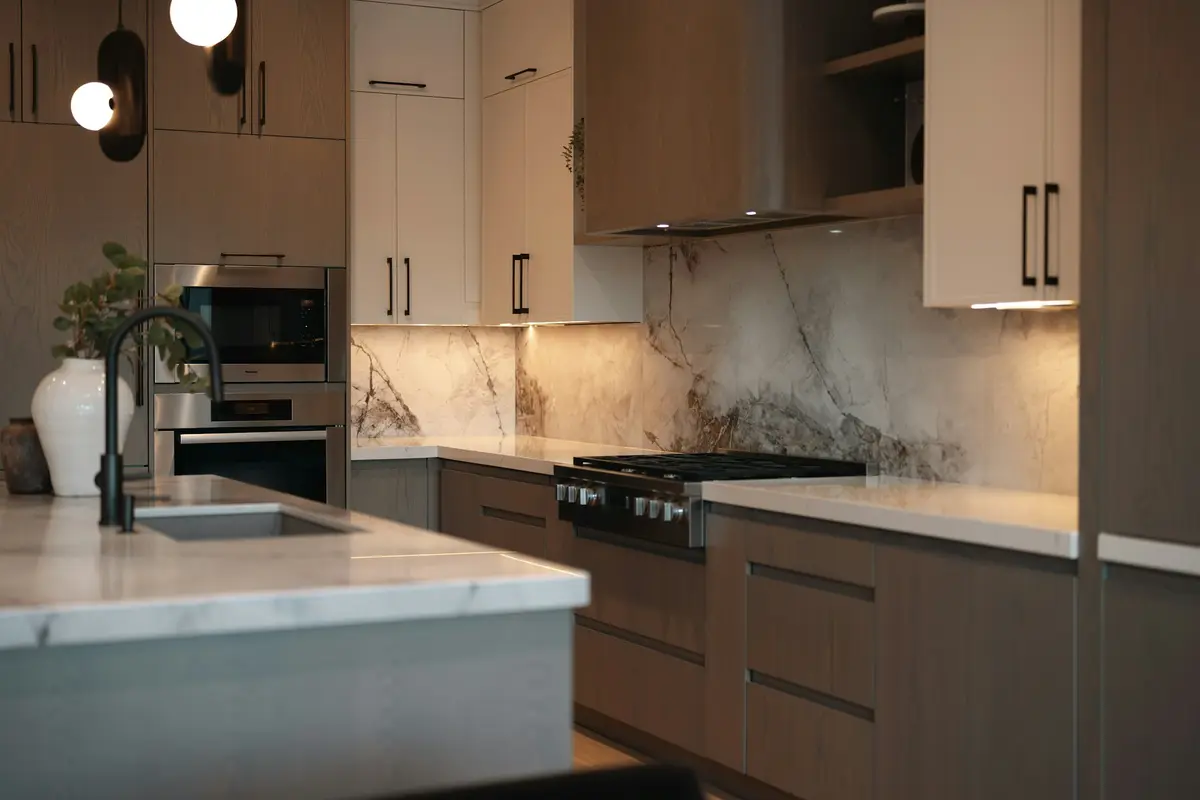 Kitchen with a marble-look backsplash behind the range and dark cabinetry
